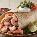 Freshly made shrimp burrito with vibrant fillings and tortilla chips on the side.