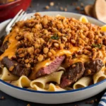 A delicious bowl of Philly Cheesesteak Pasta with beef, veggies, and cheese sauce.